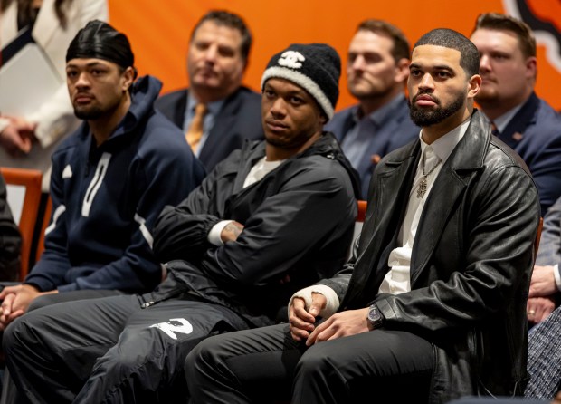 Bears players Rome Odunze, from left, DJ Moore and Caleb Williams listen as new coach Ben Johnson speaks during his introductory news conference Jan. 22, 2025, at Halas Hall in Lake Forest. (Brian Cassella/Chicago Tribune)
