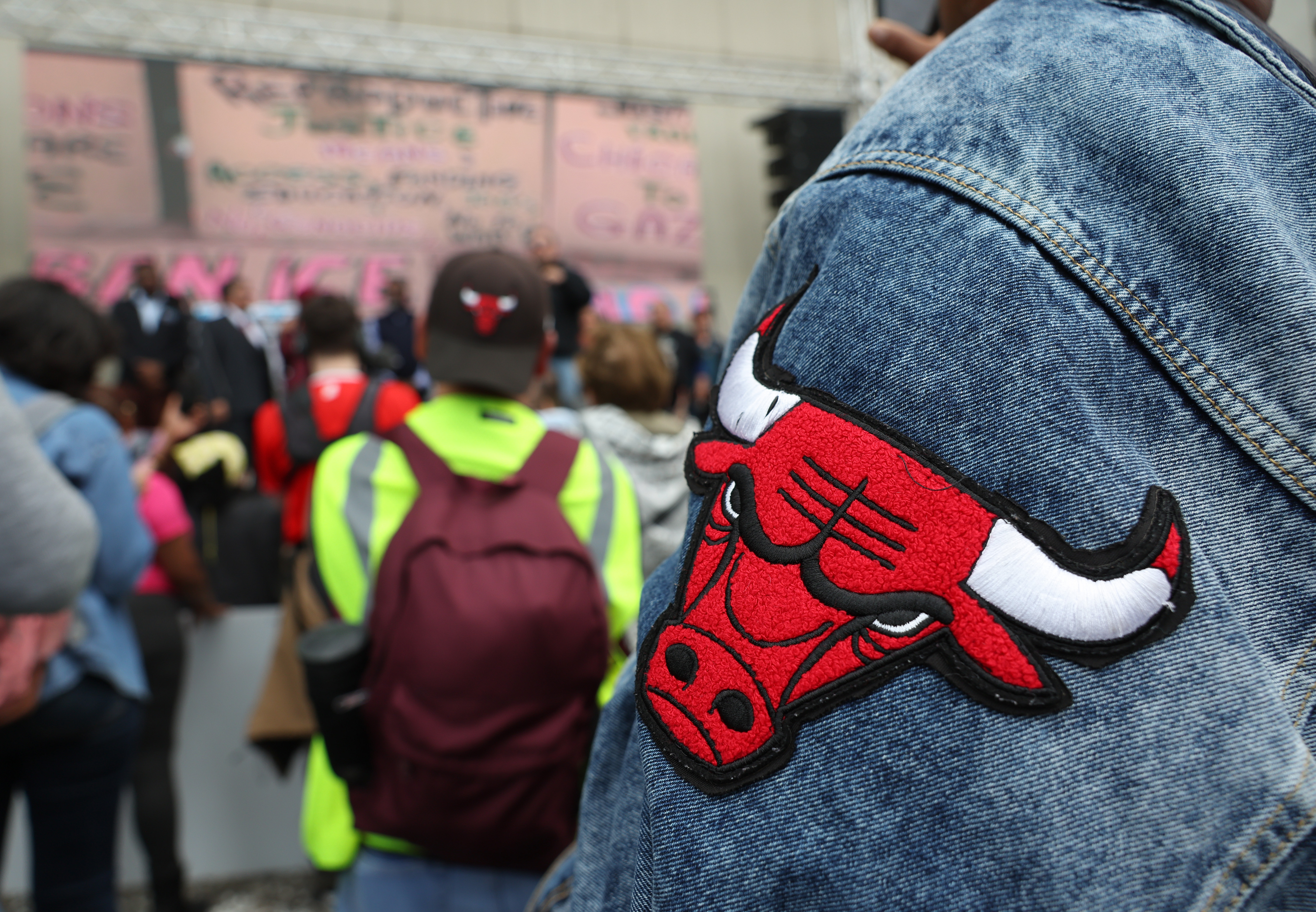 A demonstrator wears a jacket with a Chicago Bulls logo on it at a rally after a May Day march at Butler Field, May 1, 2025, in Chicago. Kilmar Abrego Garcia, a legal U.S. resident, was detained by federal law enforcement and deported on March 12 after being accused of a gang affiliation because he wore a baseball cap with the logo. (John J. Kim/Chicago Tribune)