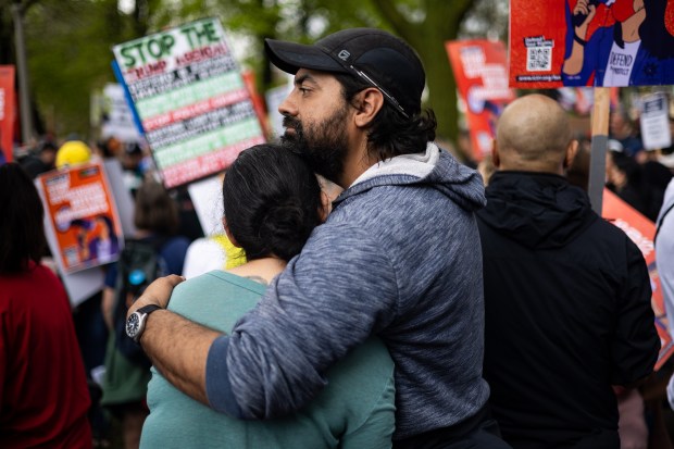 Miguel Casanova, right, holds Tawny Carrillo while gathering at Union Park before marching to Grant Park for the May Day march on May 1, 2025, in Chicago. (Audrey Richardson/Chicago Tribune)