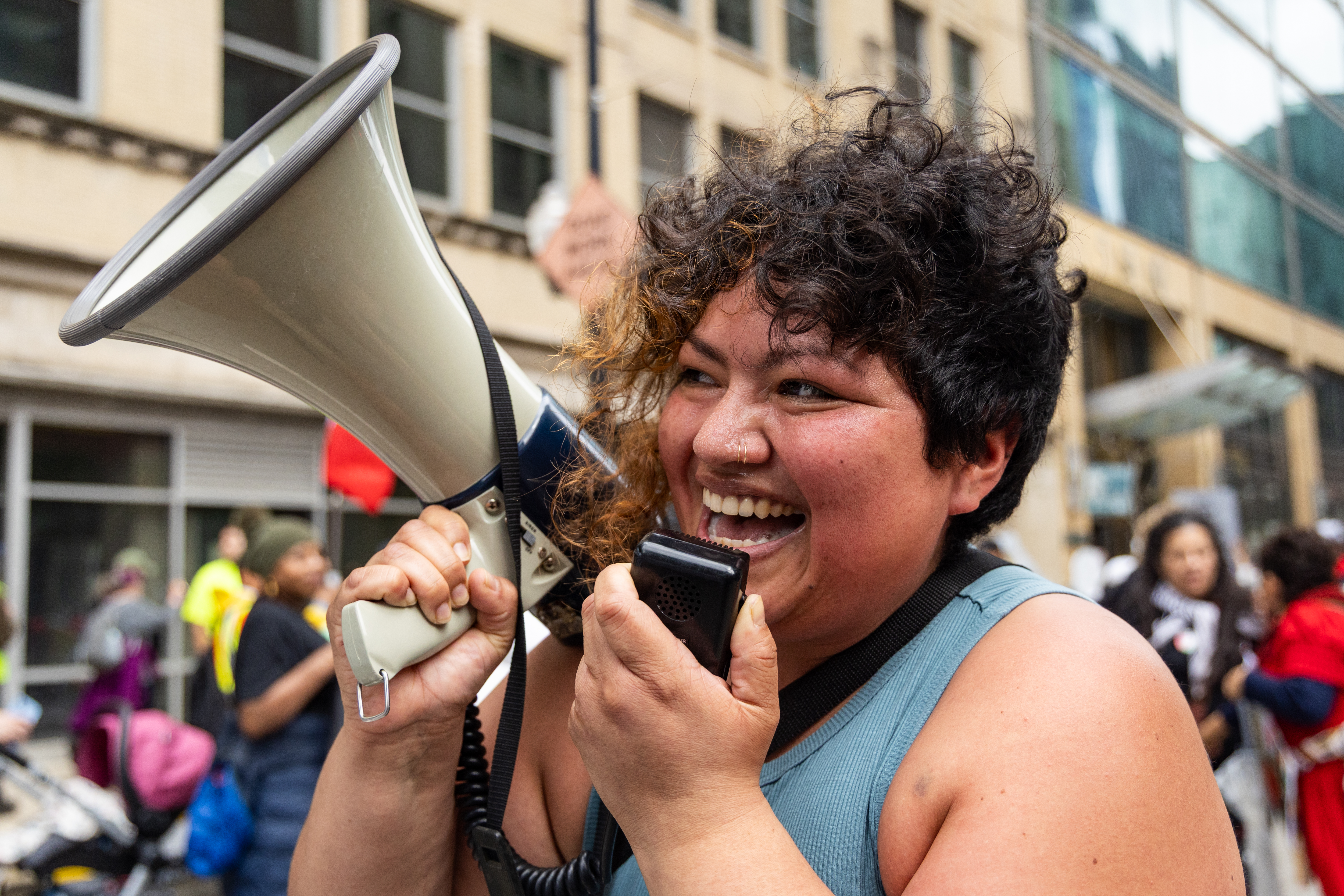 Tania Unzueta, a volunteer with Chicago Community and Workers' Rights, leads chants through a megaphone as thousands march from Union Park to Grant Park for the May Day march on May 1, 2025. (Audrey Richardson/Chicago Tribune)