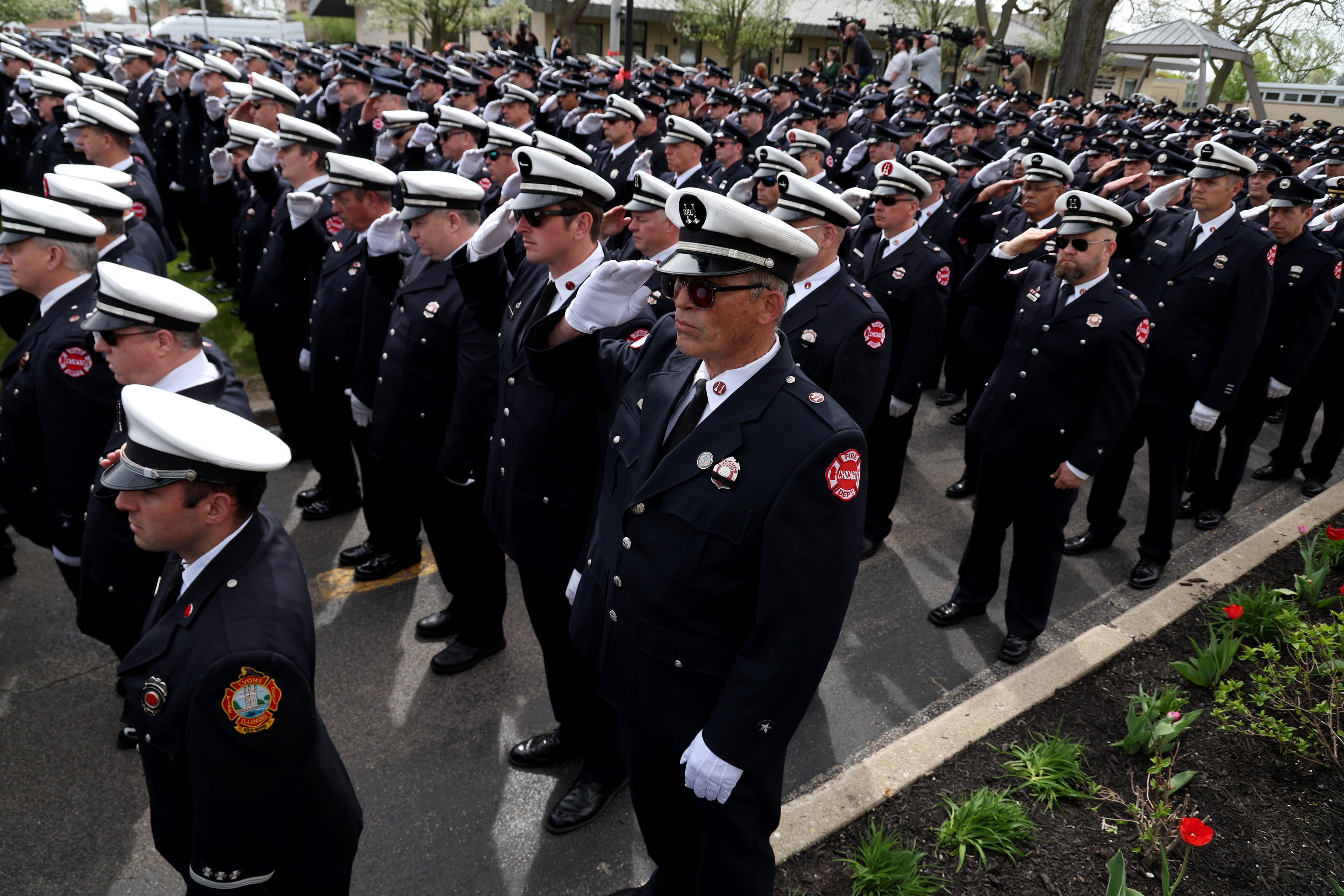 Chicago firefighters salute as a Chicago fire truck carrying the casket of fallen Chicago Fire Department Capt. David Meyer moves past toward the church during the start of funeral services at St. John Brebeuf Church in Niles, April 29, 2025. Meyer was killed in the line of duty last week battling a West Side garage fire. (Antonio Perez/Chicago Tribune)