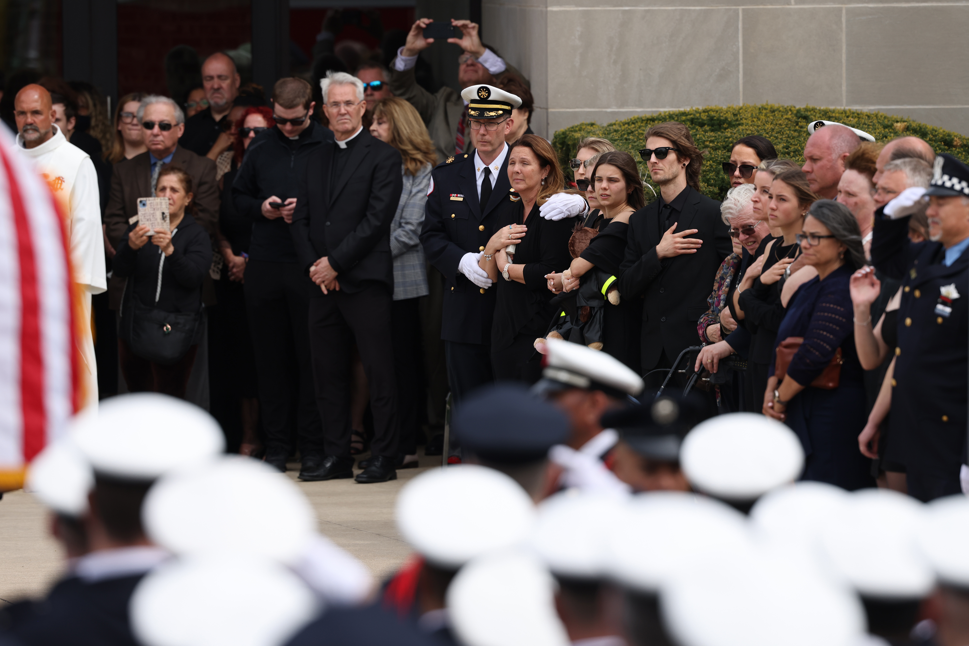 Family members and loved ones look on as the casket of fallen Chicago Fire Department Capt. David Meyer is moved into St. John Brebeuf Church in Niles, April 29, 2025. (Antonio Perez/Chicago Tribune)
