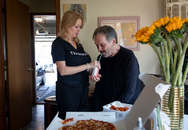 Former Chicago Bears player Steve McMichael gets help from his wife Misty eating lunch, April 22, 2021, at their Romeoville home. McMichael recently lost use of his arms after being diagnosed with ALS. The new ramp to the garage behind them was built by former teammate Dan Hampton. (Brian Cassella/Chicago Tribune)